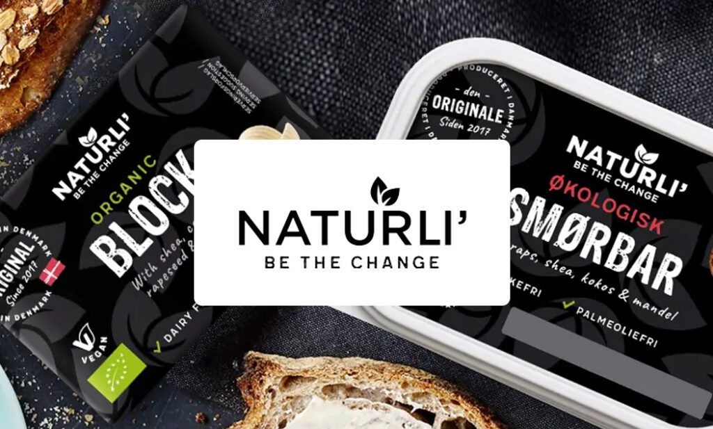 Logoet for Naturli' i forgrunden med et display af deres smørprodukter, herunder en traditionel blok smør og en smørbar variant, i baggrunden