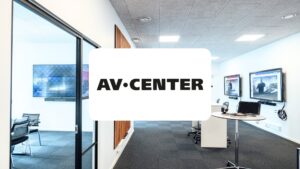Moderne kontorlandskab med AV-løsninger og AV CENTERs logo i forgrunden