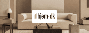 Minimalistisk stueindretning med beige sofa, sorte og træ detaljer, og teksten 'hjem.dk' nederst.