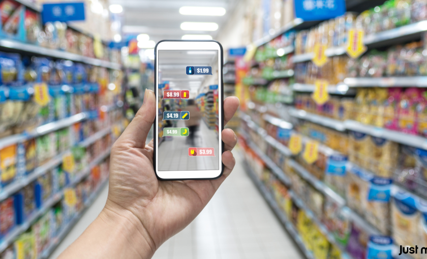 Person bruger en smartphone med Augmented Reality til at købe mad i supermarkedet. JustMA-logo i nederste højre hjørne